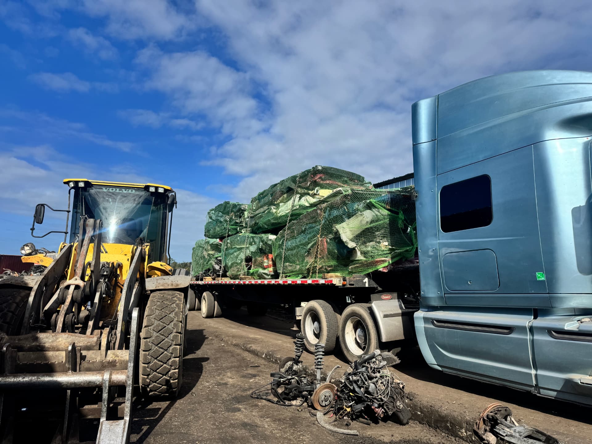 Forklift loading baled scrap onto a flatbed