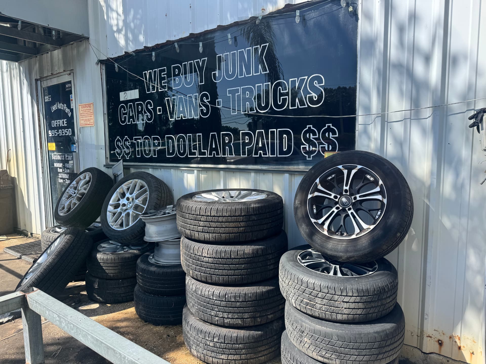 We buy junk cars sign with stacked tires